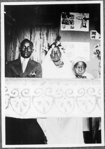 Bridal couple and girls at a table, Tanzania, 1937