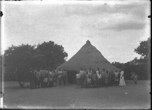 Group of people in front of a hut, Antioka, Mozambique, ca. 1901-1907