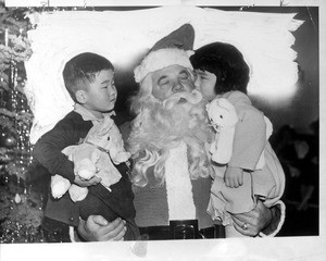 "Japanese orphans, good Americans, were not forgotten by Santa. At a Fraternal Order of Eagles (Hollywood) party, Joe Mari and Sumi Kukasowa met St. Nick."--caption on photograph