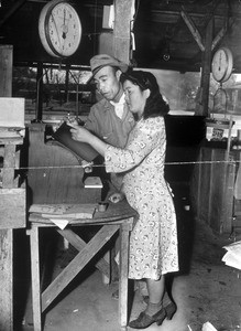 "George Hickey, Japanese alien who operates vegetable stand in prohibited area opposite Vultee plane factory, shown with his Nisei wife, Mrs. May Hickey, who will take over business when he leaves."--caption on photograph