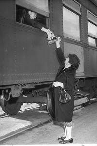 "Although lunches were provided for Japs who left by train, friends and relatives passed a great deal of food-stuffs through windows. Here go two bottles of soda pop."--caption on photograph