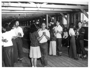 "Dancing is among the most popular diversions for the younger Japanese evacuees sent to Manzanar relocation center, as evidenced by this glimpse of several couples in a dancing class which is conducted in a girls' recreation hall."--caption on photograph