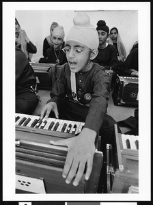 Young Sikh boy singing while playing harmonium, Vermont Sikh Temple, Los Angeles, 1999