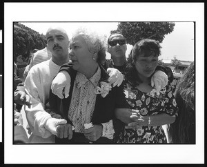 Two mourning women being comforted by two young men, S. Alanzo, Los Angeles, 1996