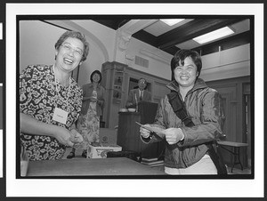 Two people of Chinese origin in front of a stage giving award, Cameron House, Family Day, Chinatown. San Francisco, California, 2002