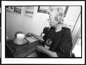 Old woman of Chinese origin lighting a candle with incense sticks. Ling Shen Ching Tze Temple, Chicago, Illinois, 2002