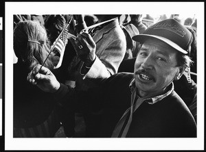 Hispanic man waving American flag in crowd, IAF-INS, Los Angeles, 1996