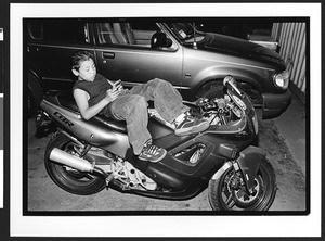 Teenager of Vietnamese origin resting on motorcycle, Harvest Moon Festival, Tet Trung Thu, San Jose, California, 2002