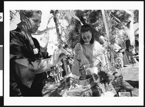 Man blessing religious statue in garden, Los Angeles, 1999