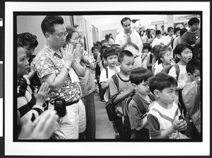 Adults and children of Vietnamese origin, praying. Chua Duc Viên Pagoda, or Perfect Harmony Temple, San Jose, California, 2002