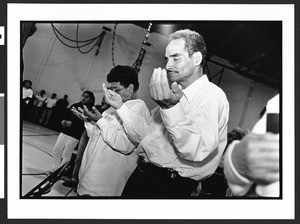 Man and woman of South American origin praying during Mass, Langley Park-McCormick Elementary School, Hyattsville, Maryland, 2002