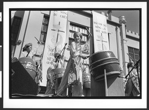 Three young women of Vietnamese origin wearing traditional Vitenamese clothing and playing traditional Vietnamese drums, Our Lady of Peace, San Jose, California, 2002