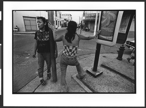 Two prostitutes of Hispanic origin standing on street corner, downtown San Salvador
