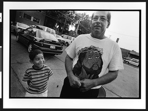 Man & boy at outdoor prayer meeting, Maternity B.V.M., Chicago, Illinois, 2002