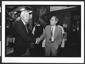 Two men of Chinese origin greet each other at Cameron House, Family Day, Chinatown, San Francisco, California, 2002