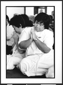 Two women of Thai origin kneeling at Wat Thai Temple, North Hollywood, Los Angeles, 2003