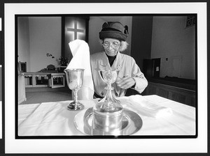 Elderly woman dresses the altar at Zion Lutheran Church before the church service, Tacoma Park, Maryland,2002