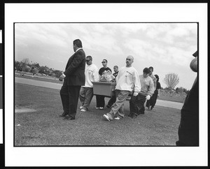 Group of men in sweatshirts carrying coffin at funeral, S. Alanzo, Los Angeles, 1996