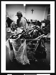 Shopping cart filled with jackets and cans in a church, Los Angeles, 1999