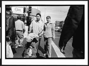 Young man and woman of Chinese origin pushing a baby in a carriage on Sacramento Street, Chinatown, San Francisco, California, 2002