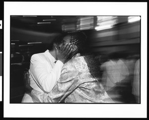 Women hugging at the First African Methodist Episcopal Church (Los Angeles, Calif.) on Easter Sunday, 1996