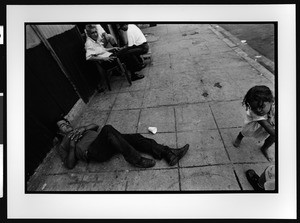 Drunken man, of Hispanic origin, lying on the sidewalk, downtown San Salvador