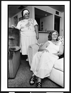 Marissa, standing in the background, Santeria priestess, also known as a lyalrishas, or mother of Orisha, the Santeria god, in her home,399 NW 72nd Avenue & 3rd Street, Miami, Florida, 2002