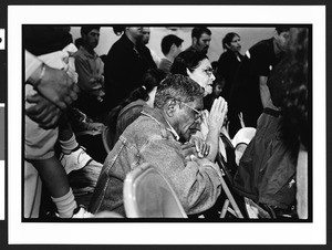 Man and woman of South American origin praying during Mass, Langley Park-McCormick Elementary School, Hyattsville, Maryland, 2002