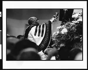 Minister at First African Methodist Episcopal Church (Los Angeles, Calif.) holding up chalice on Easter Sunday, 1996