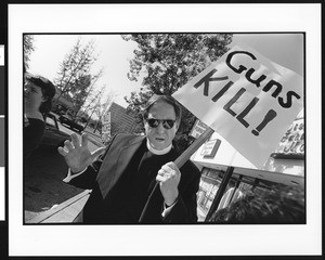 Man protesting with a handmade "Guns Kill!" sign, Pasadena Co. NVC 1996