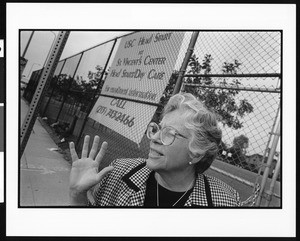 Woman in front of fence and sign for St. Vincent Child Development Center (Los Angeles, Calif.), 1996