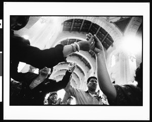 Hand holding in procession at Palm Sunday service, St. Vincent's, Los Angeles, 1996