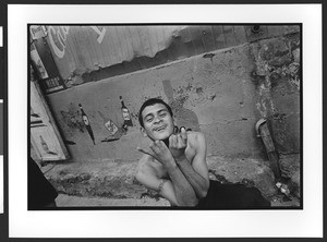 Young man of Hispanic origin, giving a gang sign, downtown San Salvador