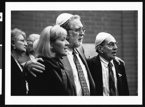 Man in prayer meeting with arms around man and woman, Los Angeles, 1999