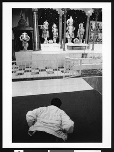 Man prostrating before the altar of Hindu deities, Los Angeles, 1999