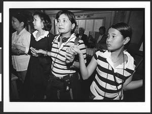 Four women of Filipino origin, holding hands, Saint Patrick's Catholic Church, San Francisco, California, 2002