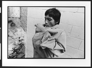 Young man of Hispanic origin lighting up a crack pipe, downtown San Salvador