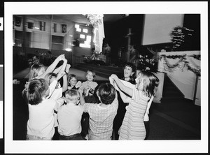 Group of children holding hands in church, Los Angeles, 1999