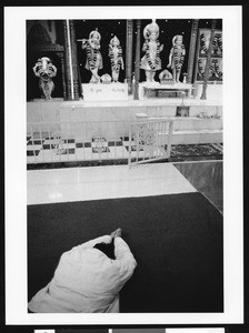 Man prostrating before the altar of Hindu deities, Los Angeles, 1999