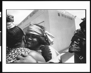 Two women hug outside church, Lighthouse Christian Fellowship, Los Angeles, 1996