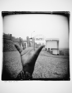 Raised hand against the background of Gisozi Genocide Memorial Site, Rwanda, 2010