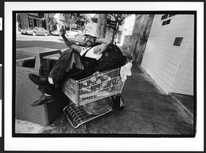 A man of South American origin sitting in a shopping cart, the Mission District, San Francisco, California, 2002