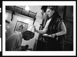 Woman placing Hindu religious article on man's head, Los Angeles, 1999