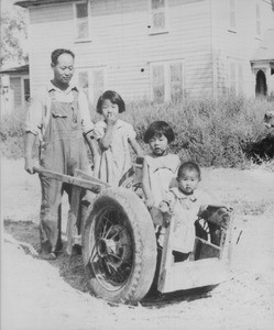 Meung Sun Paik with three daughters in wheelbarrow