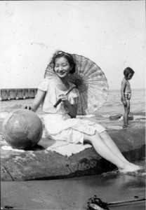 Sunda Hur at beach with parasol and beach ball, Selma Hahn in background