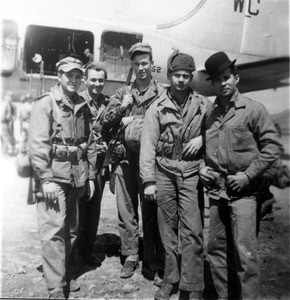 Five Marines posing outside an airplane