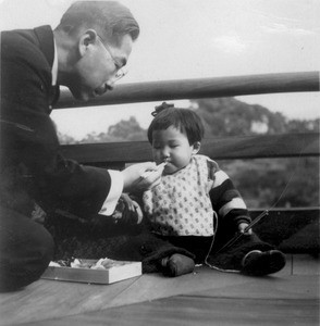 Japanese father feeds his infant daughter