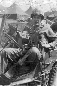 Martin Bolhower in a jeep with his rifle and camera