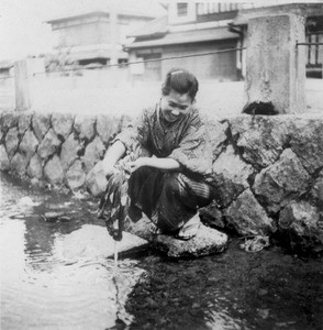 Japanese woman washing clothes in river