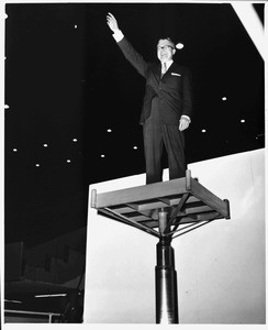 J. Leonard Reinsch tries out "presentation platform" elevator at Los Angeles Memorial Sports Arena, 1960